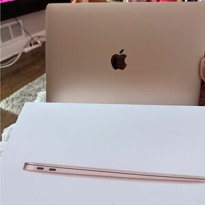 Apple Laptop in Elegant Gold and Apple ultra watch 49mm and Apple AirPods